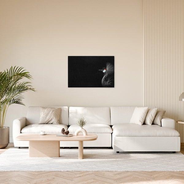 Wohnzimmer mit Sofa, Tisch und einem Bild eines Vogels an der Wand.