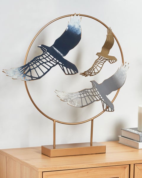 Dekorative Adlerfiguren in einem goldenen Ring auf einem Tisch