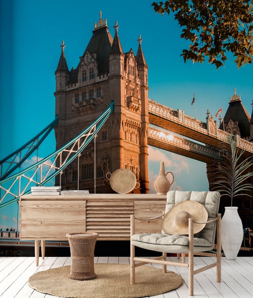 Fototapete mit Tower Bridge in London in einem Raum mit Holzkommode und Korbsessel.