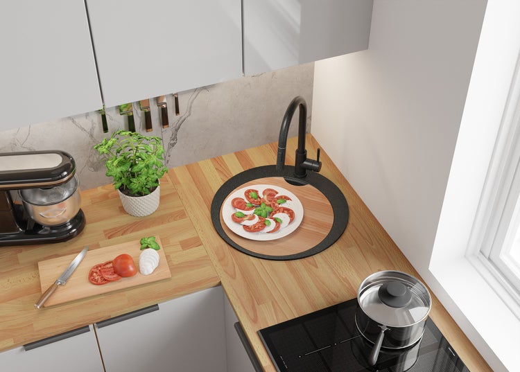 Helle Küche mit Spüle, Armatur, Herd, Schneidebrett und Speisen