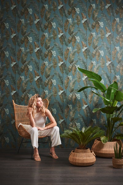 Frau vor einer Wandtapete mit Blattmuster