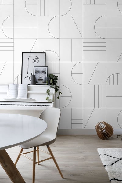 Wohnraum mit grafischer Tapete, Esstisch, Stuhl, Klavier und Stehlampe