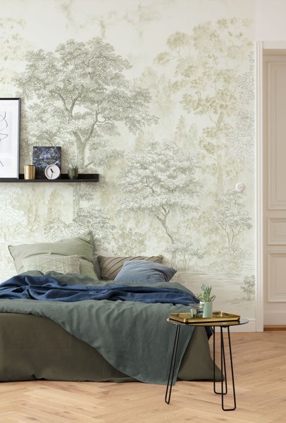 Schlafzimmer mit Wandtapete mit Waldmotiv, Bett und Nachttisch