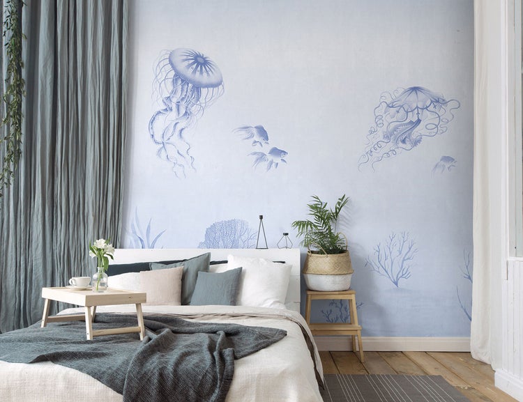 Schlafzimmer mit Doppelbett, Nachttisch, Bettwäsche und Wandtapete mit Meeresmotiven