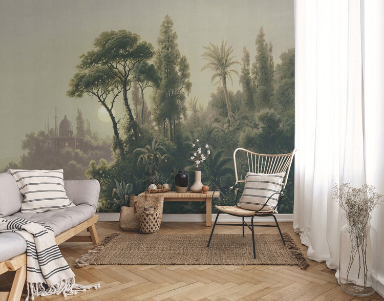Szene mit einer Wandtapete, die eine Waldlandschaft mit einem Gebäude darstellt, ergänzt durch Möbel und Dekorationen.