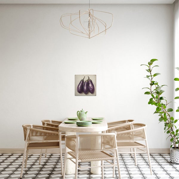 Esszimmer mit Esstisch, Stühlen und einem Bild von Auberginen an der Wand
