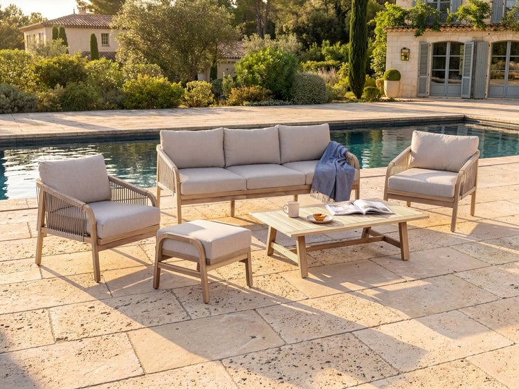 Loungemöbel-Set aus Holz auf einer Steinterrasse am Pool, bestehend aus Sofa, zwei Sesseln, Hocker und Couchtisch mit hellen Polstern.