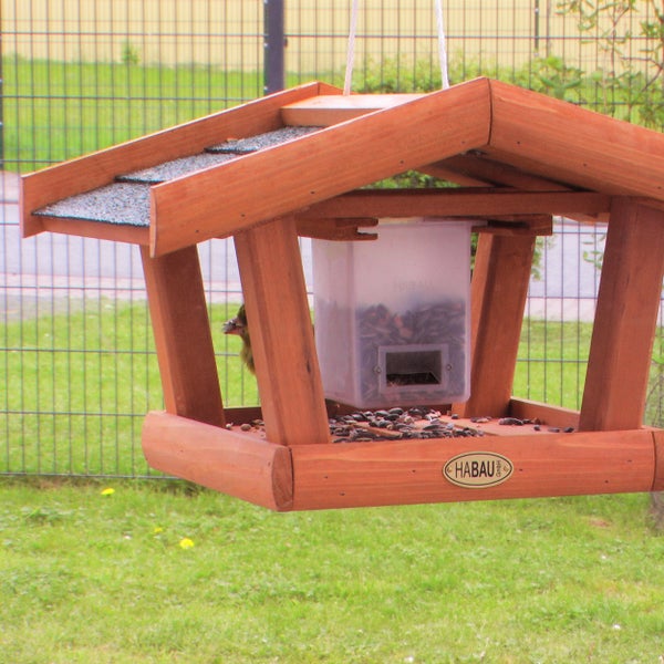Hängendes Vogelhaus aus Holz mit Vogelfutter