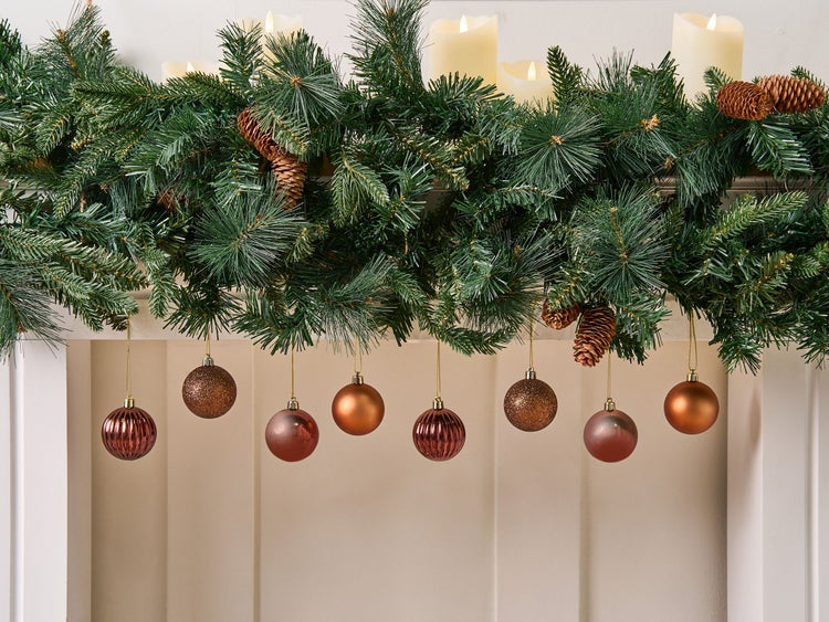 Dekorativer Weihnachtsschmuck mit Tannengirlande, Kerzen und Christbaumkugeln