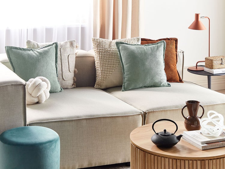 Wohnzimmer mit Sofa, Kissen, Tisch und Dekoration