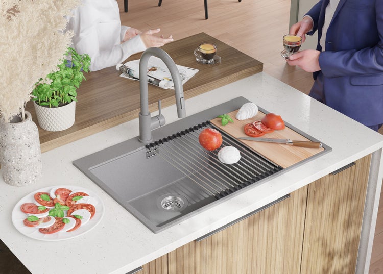 Spüle aus Granit mit Abtropfgestell, Armatur und Schneidebrett in einer hellen Küche
