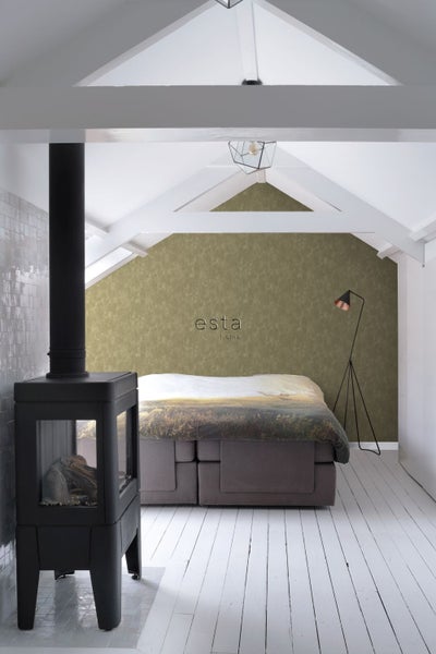 Schlafzimmer mit Kaminofen, Bett und Stehlampe in einem hellen Raum mit Dachschrägen