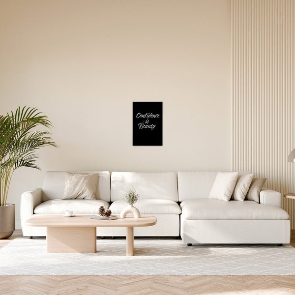 Wohnzimmer mit Sofa, Tisch und gerahmtem Zitat an der Wand