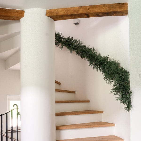 Treppe mit Holzstufen und Girlande an der Wand