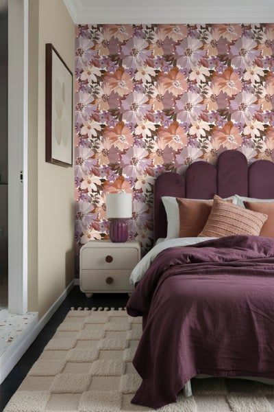 Schlafzimmer mit floraler Tapete, Bett und Nachttisch