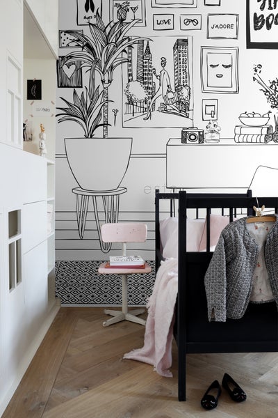 Schlafzimmer mit schwarzem Bett, Schreibtisch und Mustertapete