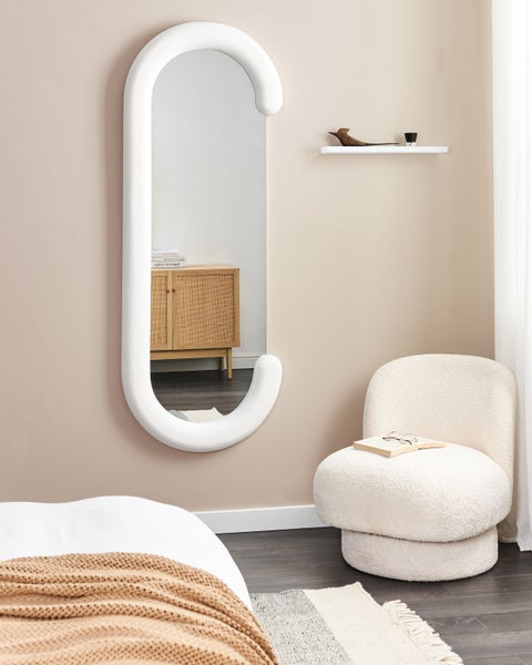 Dekoratives Schlafzimmer mit Spiegel, Stuhl und Ablage
