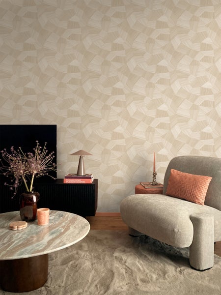 Wohnzimmer mit beiger Tapete, Sessel und Tisch