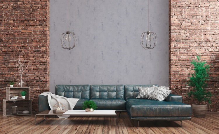 Dekorative Vasen und Bücher auf einem Schrank mit Rattanfront vor einer strukturierten Tapete.