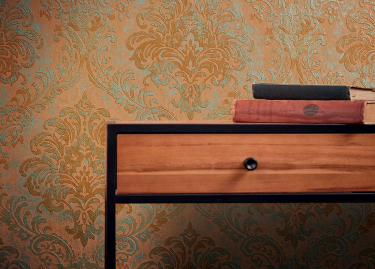 Mann mit Rollkragenpullover und Uhr vor einer gemusterten Tapete