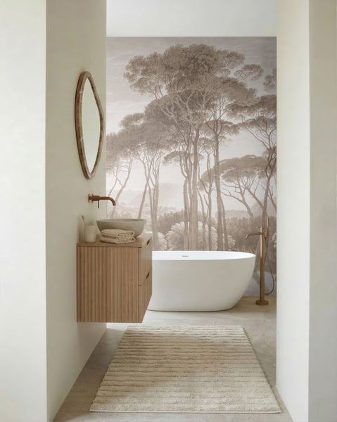 Modernes helles Badezimmer mit freistehender Badewanne, Holz-Waschtisch und Fototapete mit Waldlandschaft in Sepia.