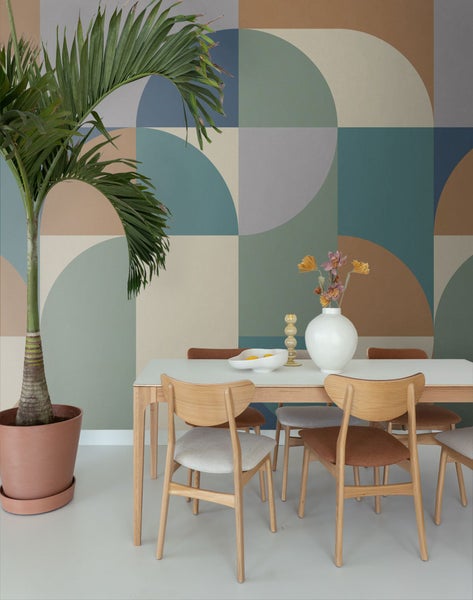 Esszimmer mit Esstisch, Stühlen, Zimmerpflanze und gemusterter Tapete