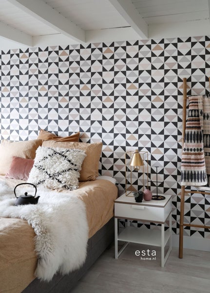 Schlafzimmer mit geometrischer Tapete, Bett, Nachttisch und Dekorationsleiter