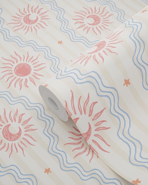 Tapetenrolle mit handgezeichneten rosa Sonnen, Mondsicheln, blauen Wellenlinien und orangen Sternen auf beigefarbenem, gestreiftem Untergrund.