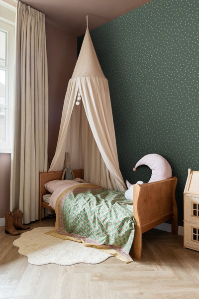 Kinderzimmer mit Himmelbett, Holzrahmenbett und gemusterter Bettwäsche