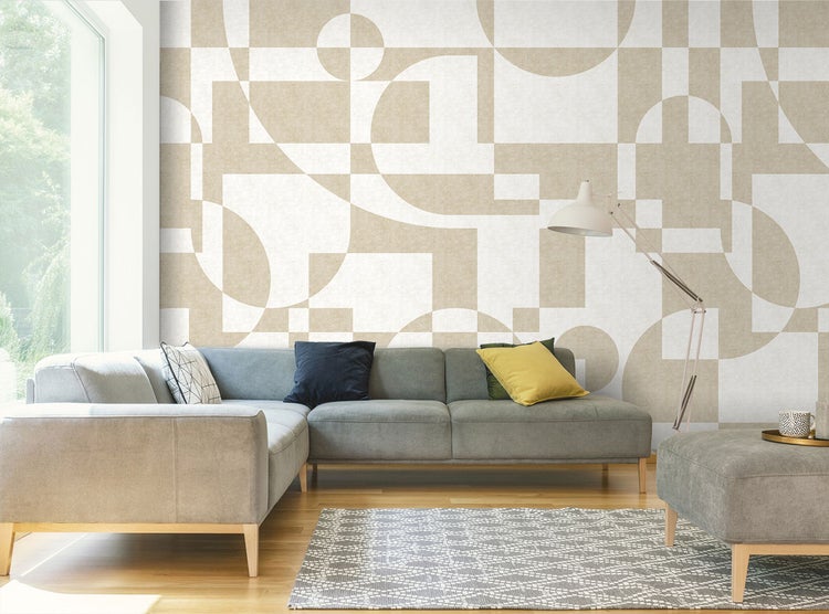 Wohnzimmer mit Sofa, Teppich und gemusterter Tapete mit geometrischen Formen