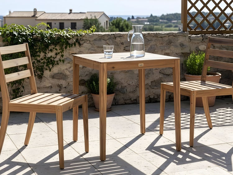 Quadratischer Holztisch mit zwei Stühlen auf einer Terrasse