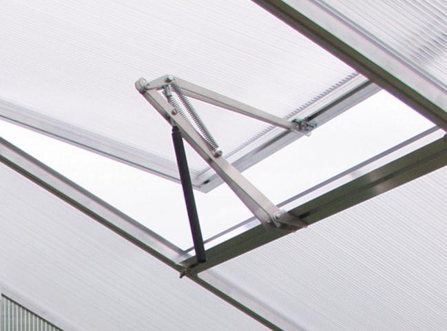 Automatischer Fensteröffner für Gewächshäuser, montiert an einem Dachfenster mit Hohlkammerplatte aus Polycarbonat.