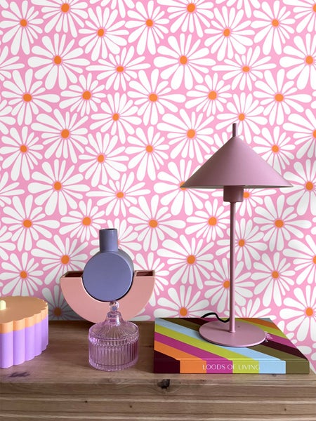 Dekoratives Zimmer mit Tapete mit Gänseblümchenmuster, Tischlampe und Ziergegenständen