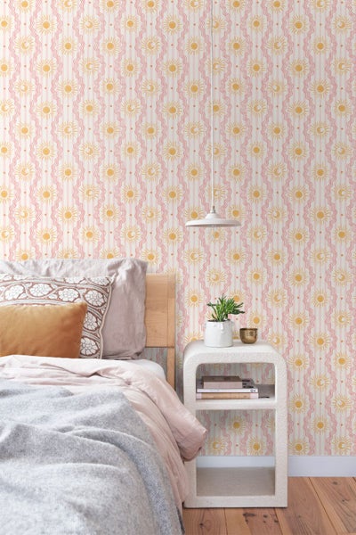 Tapete mit Sonnen- und Mondmotiv in einem hellen Schlafzimmer mit Holzbett, weißem Nachttisch und Hängeleuchte.