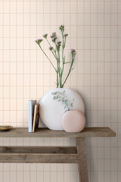 Dekoratives Arrangement mit Fliesenwand, Holztisch, Vasen und Blumen