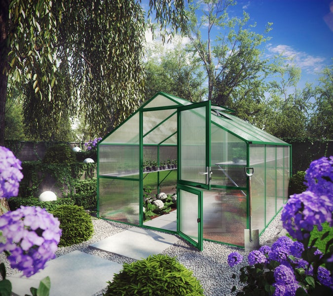 Geräumiges Gewächshaus mit grünem Metallrahmen und Doppel-Stalltür in einem sonnigen Garten mit Blumen und Pflanzen.
