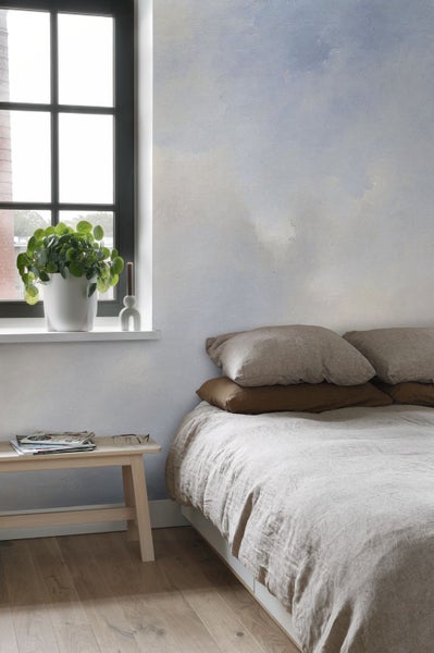 Helles Schlafzimmer mit Bett, Fenster und Pflanze auf der Fensterbank