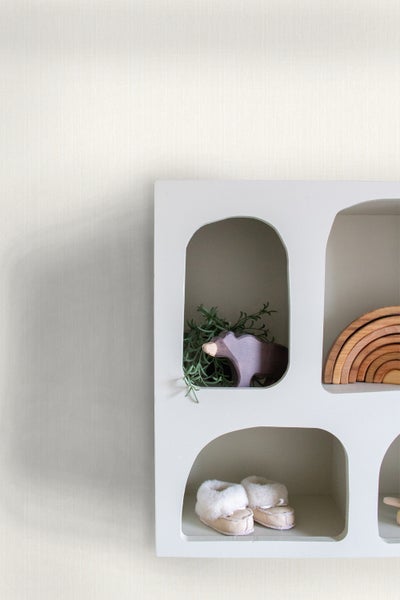 Wandregal mit Holzspielzeug und Babyschuhen