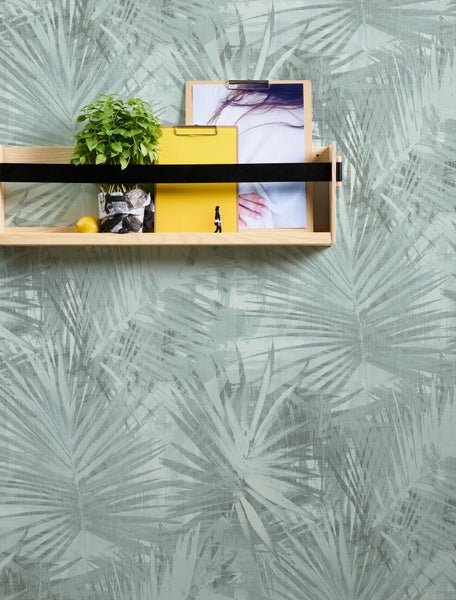 Regal mit Dekoration vor einer Wand mit Pflanzenmuster