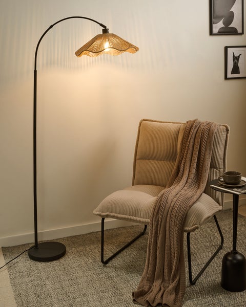 Wohnszene mit Bogenleuchte, Sessel und Beistelltisch