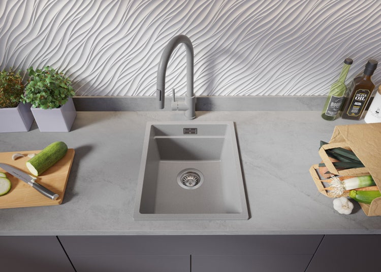 Küchenspüle aus Stein mit Armatur auf Arbeitsplatte mit Lebensmitteln