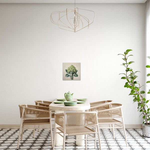 Helles Esszimmer mit Esstisch, Stühlen, Zimmerpflanze und einem gerahmten Pflanzenbild an der Wand.