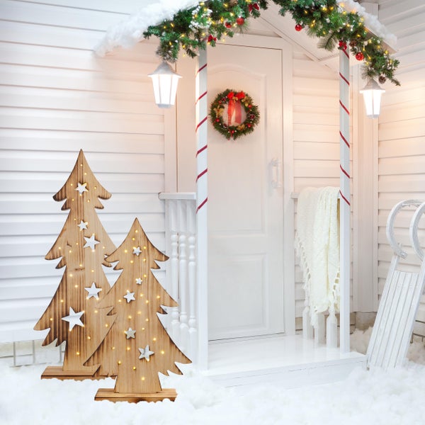 Dekorierte Veranda mit Holzweihnachtsbäumen, Kranz und Schlitten für festliche Atmosphäre