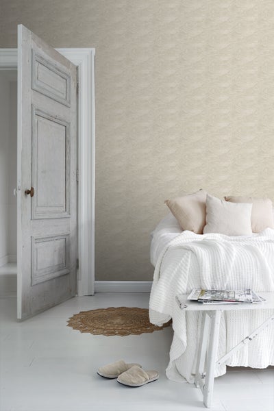 Heller Wohnraum mit gemusterter Tapete, Bett und offener Holztür