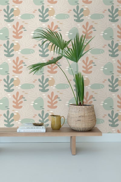 Dekorative Tapete mit abstraktem Pflanzenmuster hinter einem Regal mit Zimmerpflanze