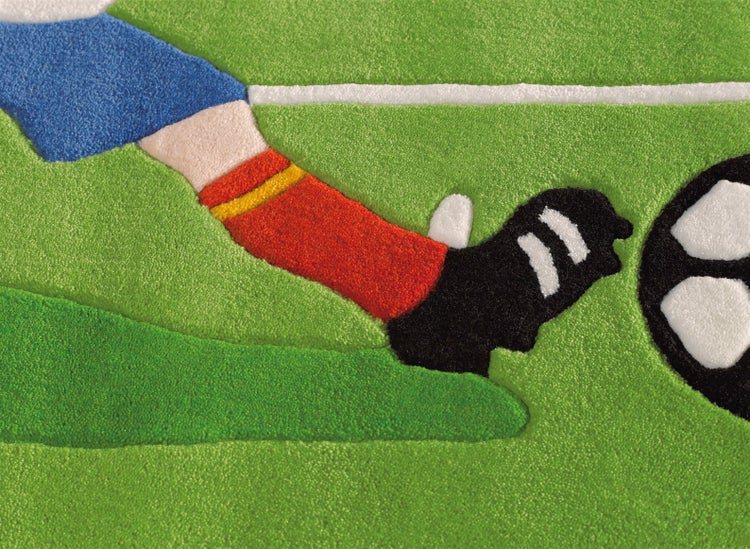 Kinderteppich mit Fußball-Motiv, zeigt einen Fuß beim Kicken eines Fußballs auf grünem Rasen.
