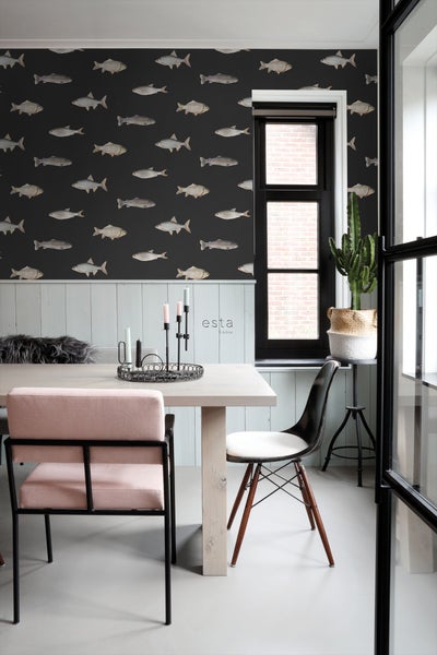 Heller Holztisch mit Stühlen und Dekor vor einer Wand mit Fischmuster-Tapete