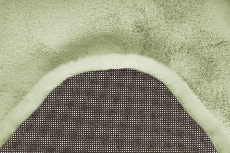Kunstfellteppich mit rutschhemmender Rückseite und weicher Oberfläche in Detailansicht.