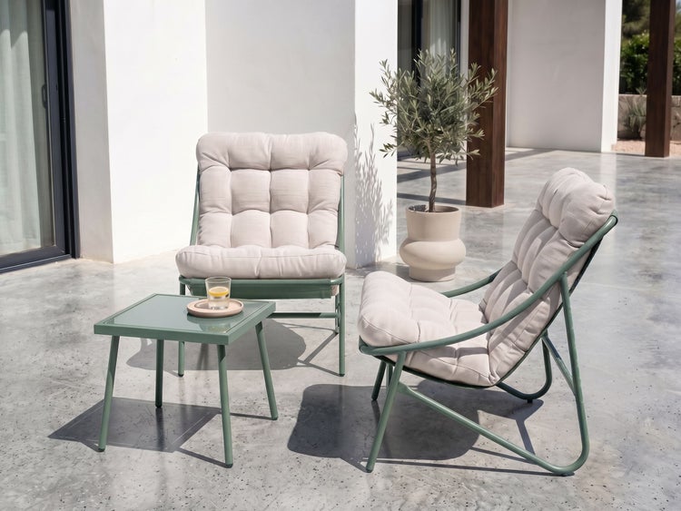 Moderne Gartenlounge mit zwei Sesseln und Beistelltisch auf einer hellen Terrasse. Grüne Metallgestelle mit dicken, gesteppten Polstern.
