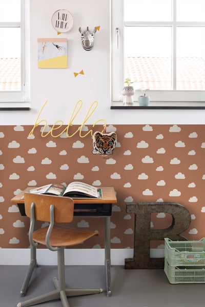 Kinderzimmer mit Schreibtisch, Stuhl, Wolkenmuster-Tapete und dekorativen Accessoires